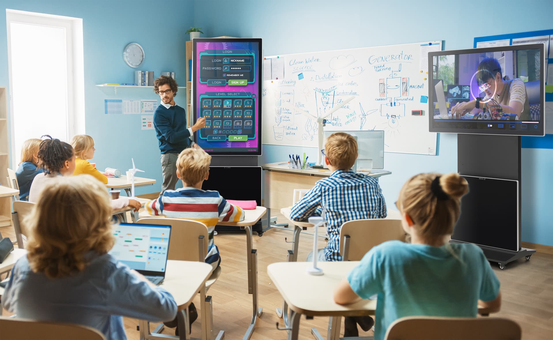 Rotating touch screen digital signage being used in a classroom setting with one screen oriented in landscape playing a video and the other in a portrait orientation showing a game that's quizzing the class on the video
