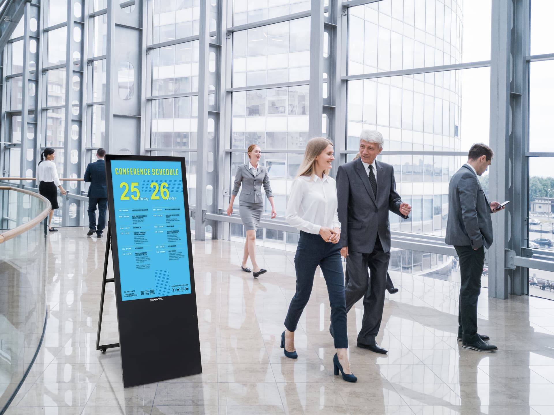 Digital sandwich board in office space with event schedule graphic on screen