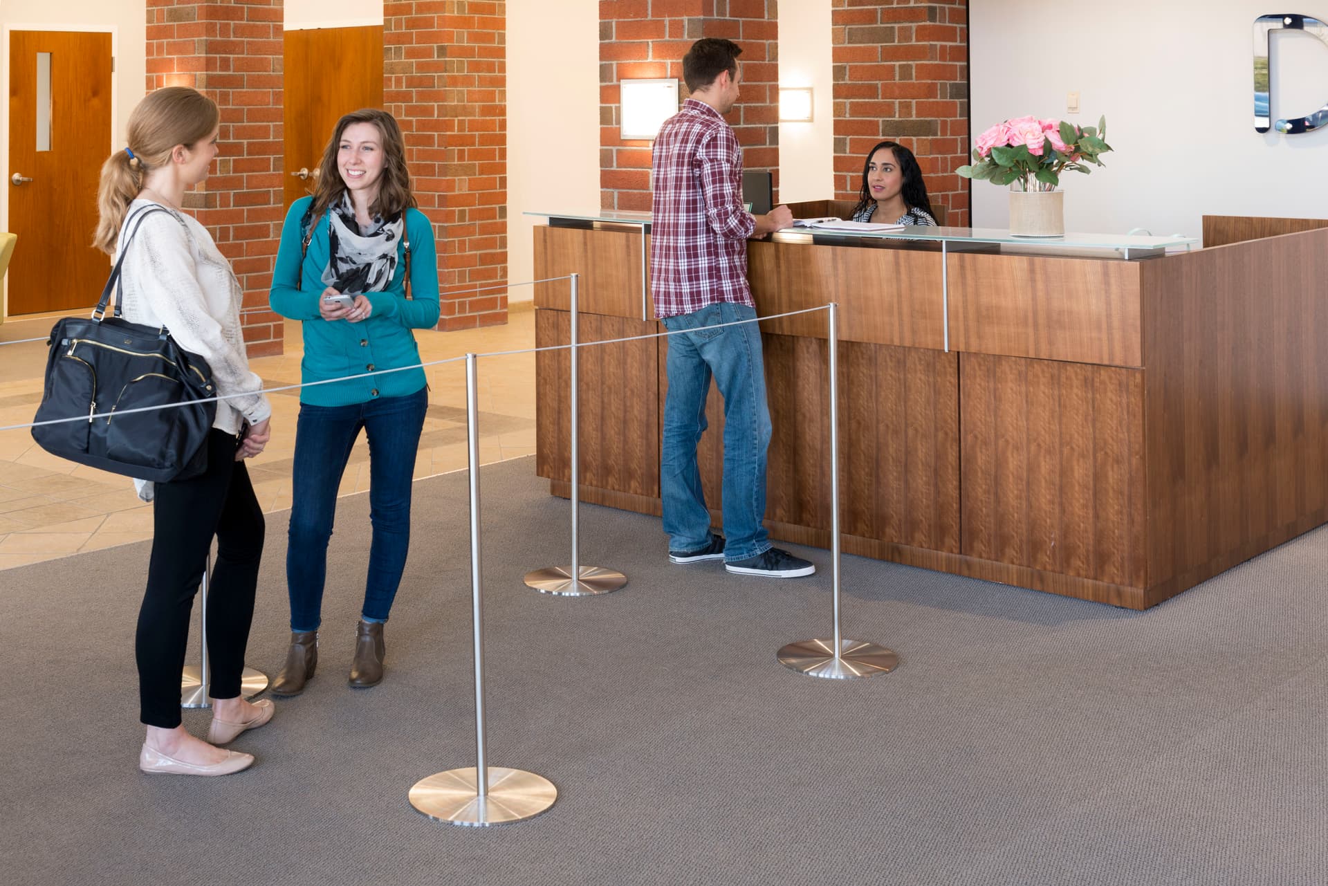 People in Queue Behind the 8-Barrier Silver Gallery Stanchion Set