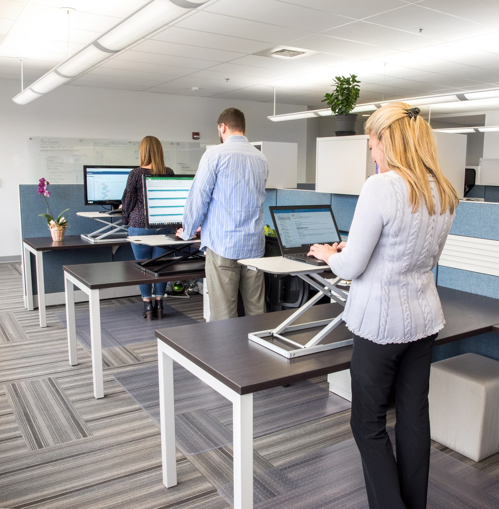 Height adjustable standing desk converter for office environments