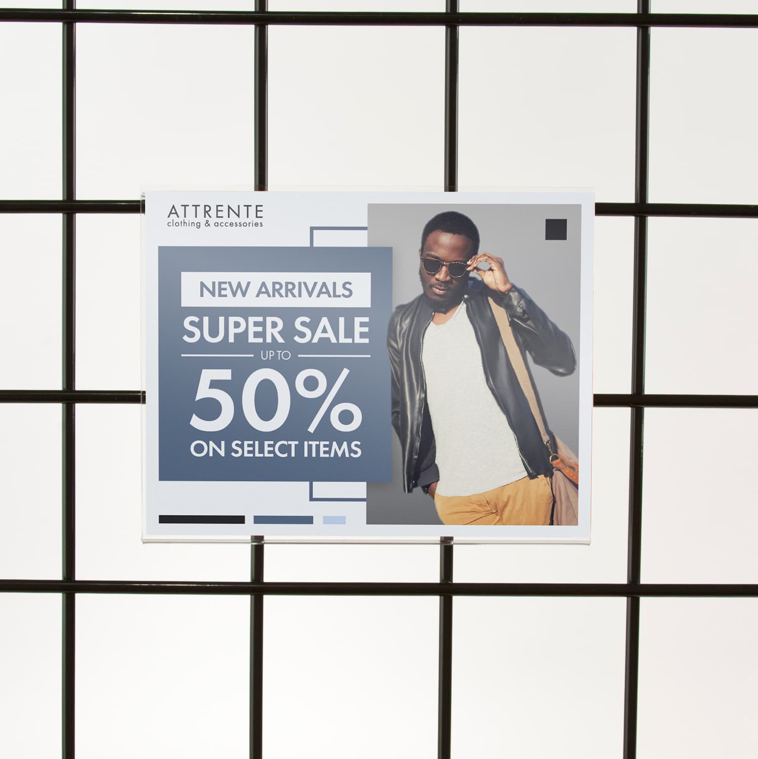 Acrylic gridwall sign holder being shown on a gridwall with a clothing advertising sale graphic