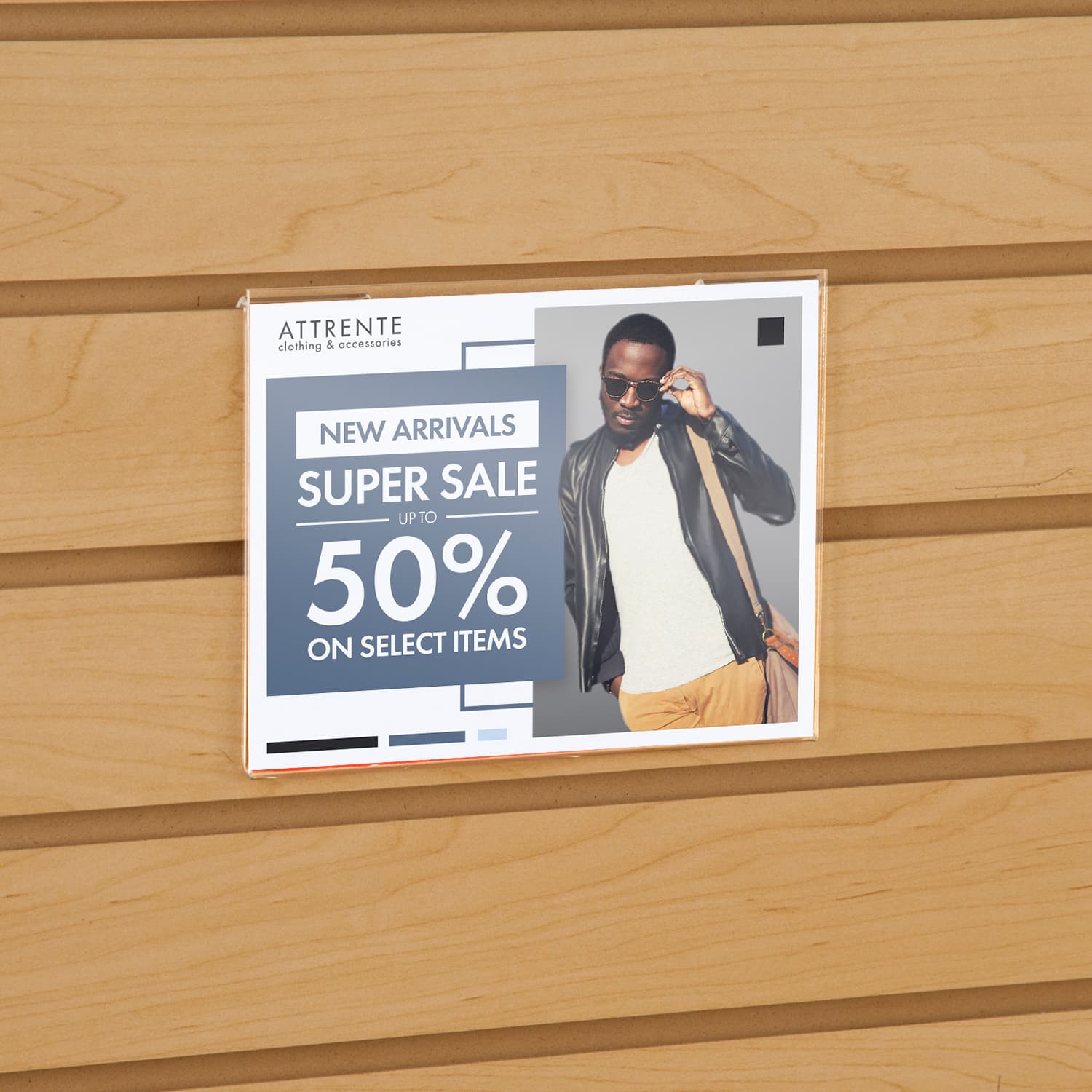 Acrylic gridwall sign holder being shown on a slatwall advertising a clothing sale