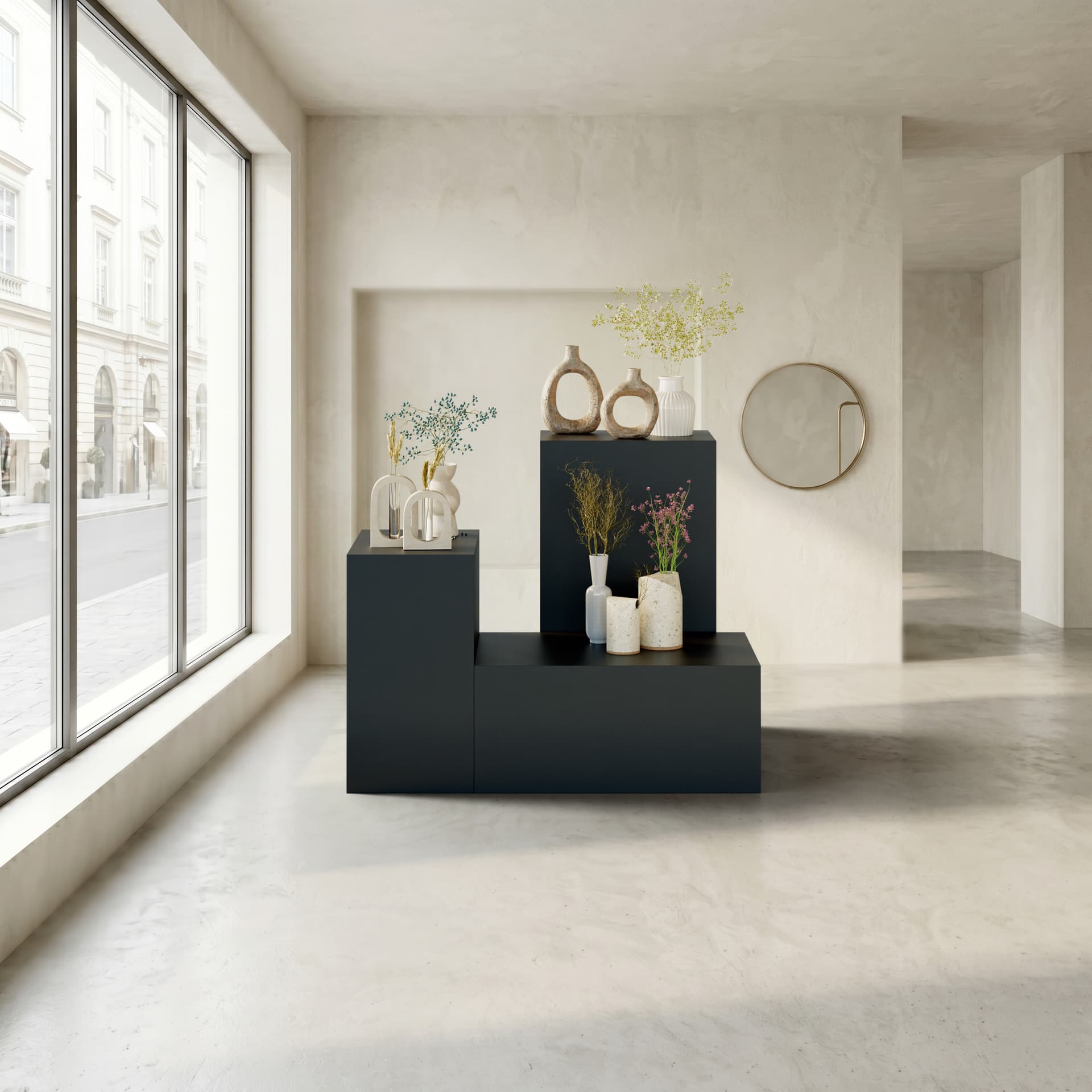 Retail display pedestal being utilized in a store front space with all three size options exhibiting items on top