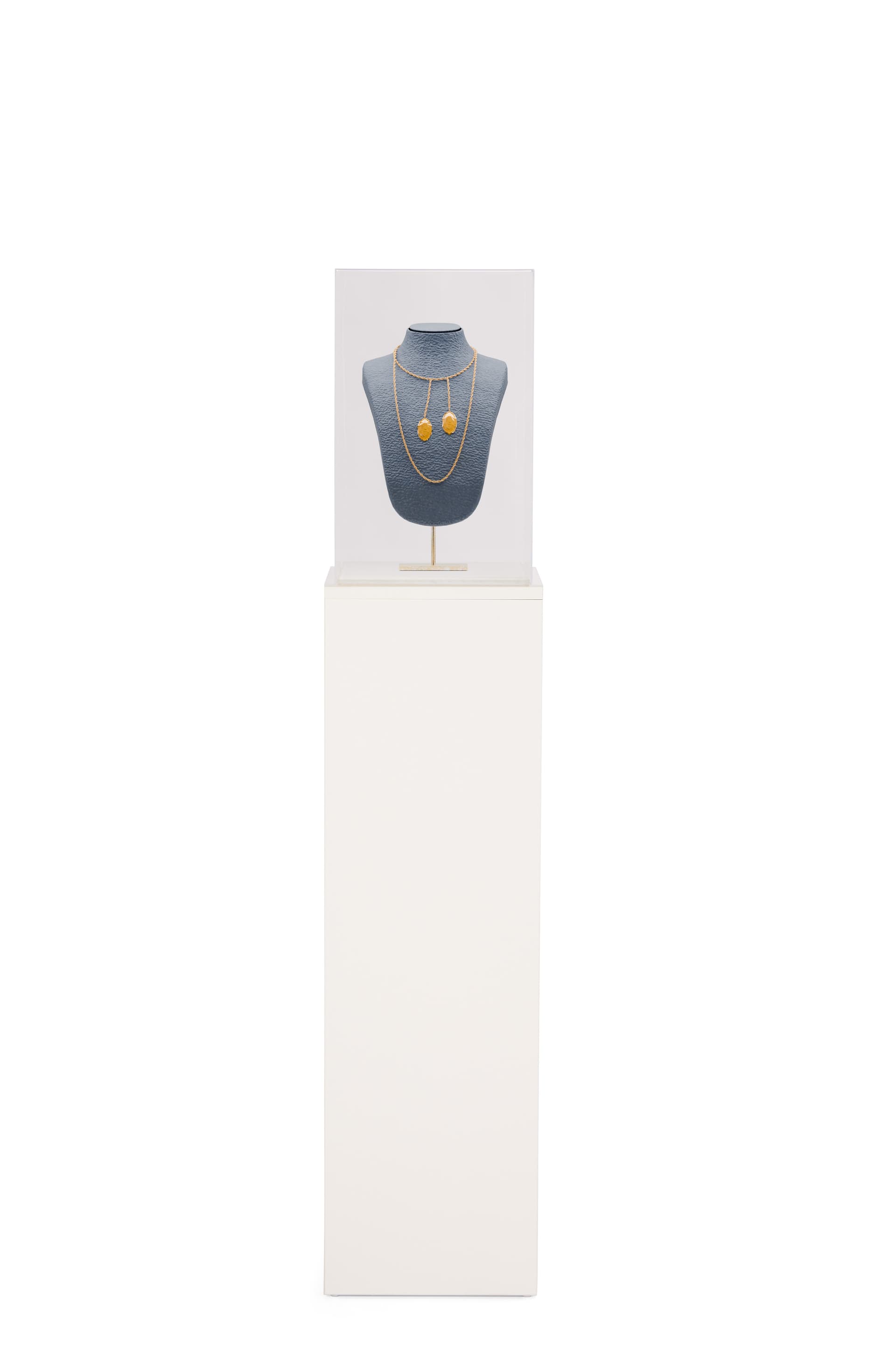 White display pedestal showcasing jewelry