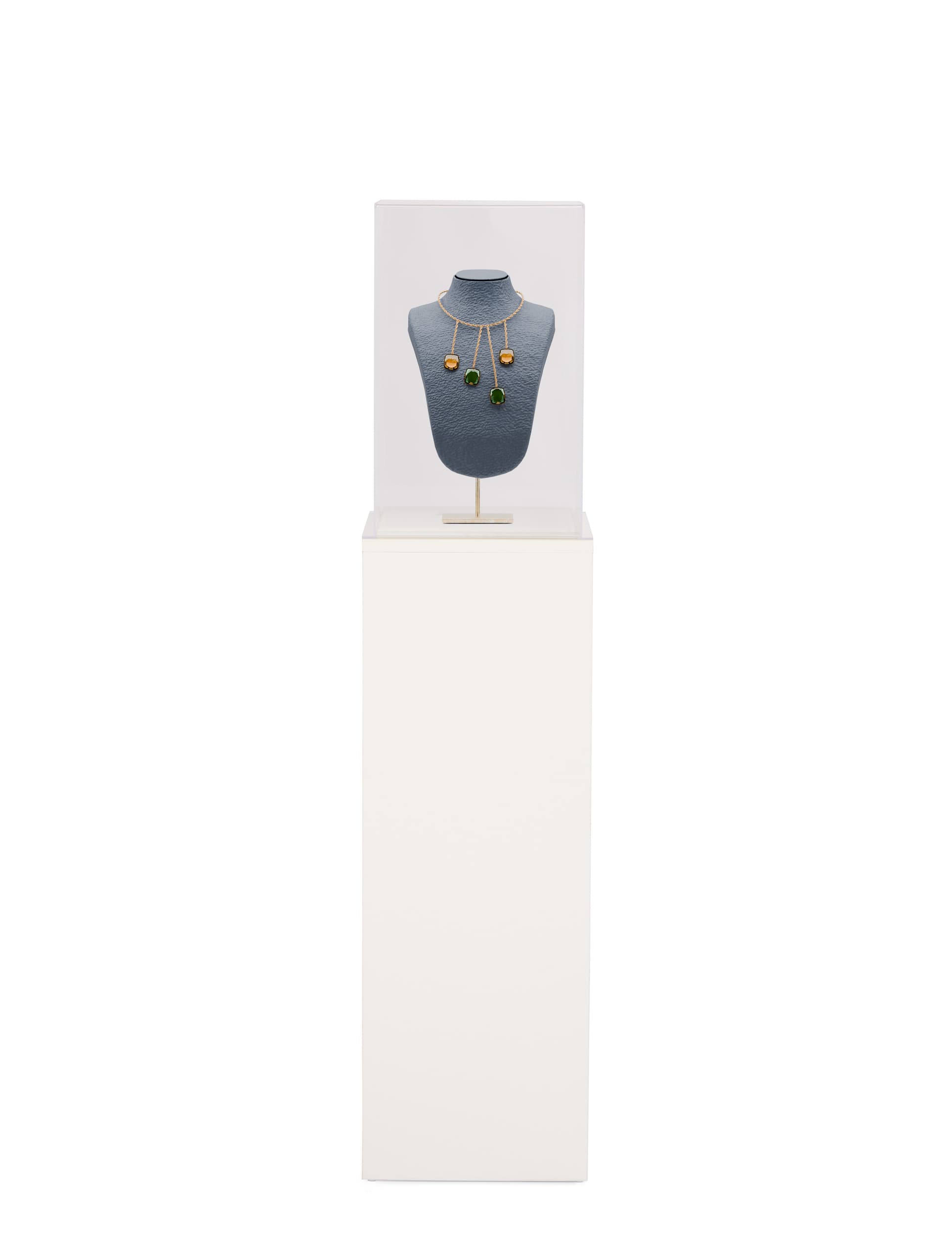 White display pedestal showcasing jewelry