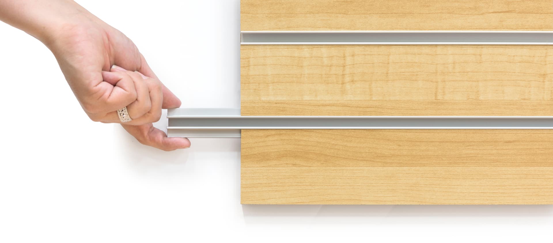 Hand Removing the Channel Insert of the Large Maple Slot Wall Panel Board