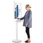 Digital charging station with an individual interacting with charging kiosk checking the charge of her phone while an advertisement for a healthcare facility plays on the screen