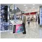 Touch screen interactive kiosk being showcased in a shopping plaza environment with a passerby interacting with it