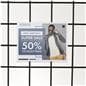 Acrylic gridwall sign holder being shown on a gridwall with a clothing advertising sale graphic