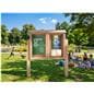 Free standing outdoor bulletin board being utilized in a community park to display messages for the public