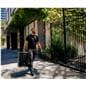 JBL column speakers being carried by one individual on a side walk in a metropolitan area